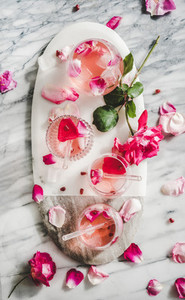 Rose lemonade with ice cubes and pink rose petals