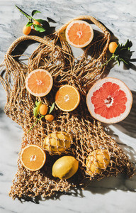 Flat lay of summer net bag with fresh ripe citrus fruits