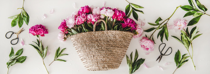 Summer flowers layout with pink and purple peonies in basket