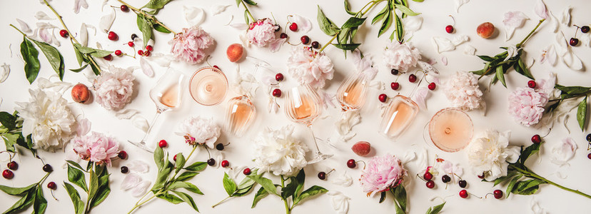 Rose wine in glasses with flowers and summer fruits