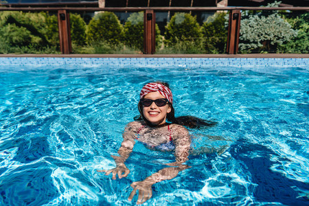 Beautiful teenage girl relaxing in pool water