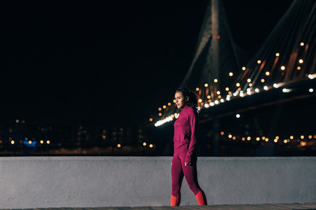Fit woman in wear sports clothes relaxing during training at night