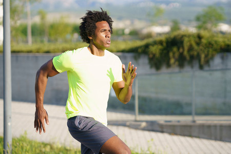 Black athletic man running in an urban park
