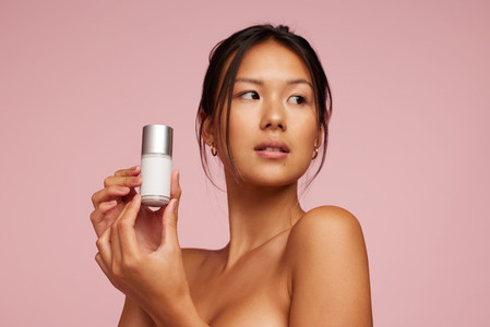 Beautiful asian woman holding beauty care product