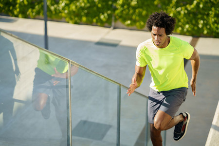Black man running upstairs outdoors  Young male exercising