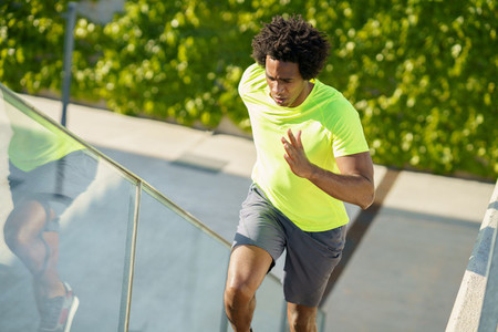 Black man running upstairs outdoors Young male exercising