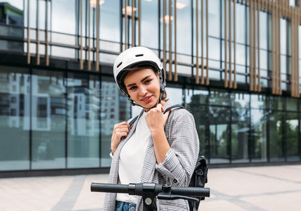 Beautiful caucasian woman in white cycling helmet posing outdoors and looking at camera