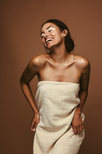 Cheerful woman dancing in bath towel