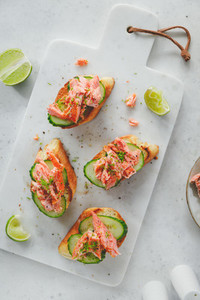 Toasts with smoked salmon and fresh cucumber served with lime shavings