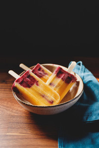 Fruit homemade popsicles made are from fresh mango  blackcurrant and coconut milk  Healthy vegan summer dessert