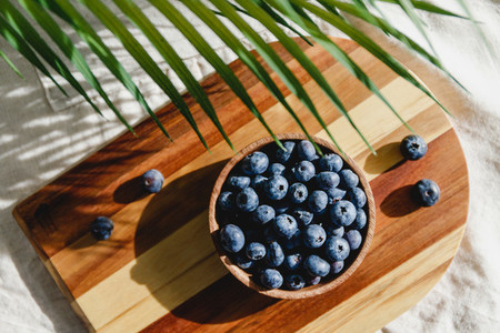 Fresh blueberry in a wooden bowl on a linen light cloth  Healthy eating and Summer concept