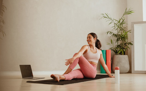 Woman doing yoga watching online class