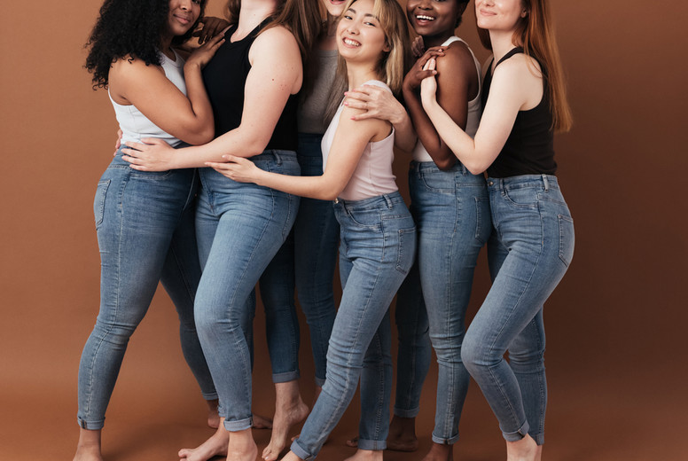 Group of cheerful women of different body type and ages standing together in a studio