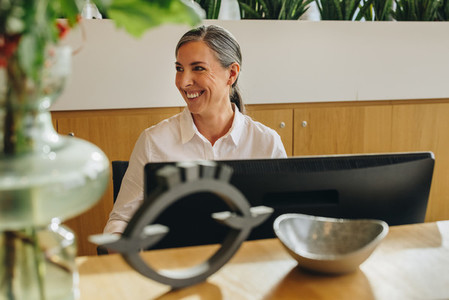 Smiling receptionist working on front desk