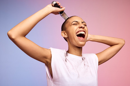 Bold female shaving off her head and laughing