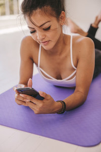 Woman relaxing after workout with a cellphone