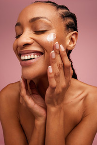 Beautiful woman applying cosmetic cream
