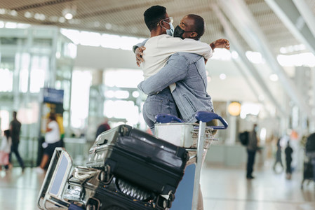 Man hugging woman at airport terminal