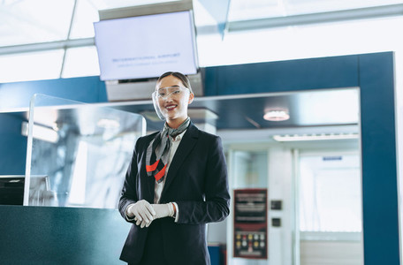 Airlines attendant with face shield standing at airport