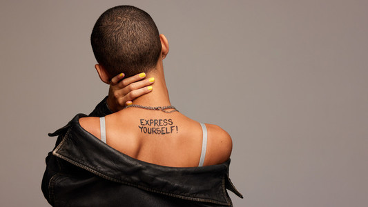 Androgynous woman with express yourself written on back