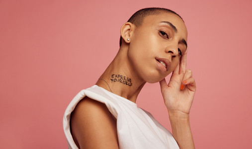 Androgynous woman against pink background