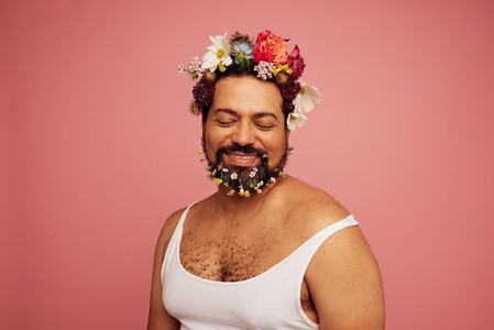 Genderqueer wearing flowers on head and beard