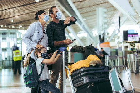 Family with luggage at airport during pandemic