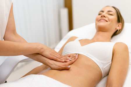 Middle aged woman having a belly massage in a beauty salon