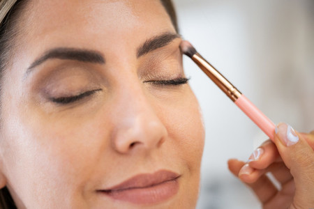 Close up of a make up artist applying eye shadow to her client