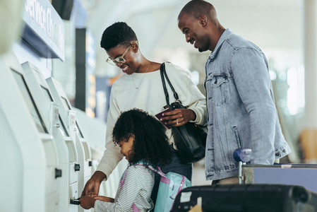 Family check in using self service machine at airport