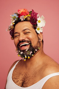 Cheerful male with flowers in hair and beard