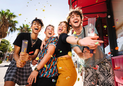 Joyful group of friends celebrating with confetti