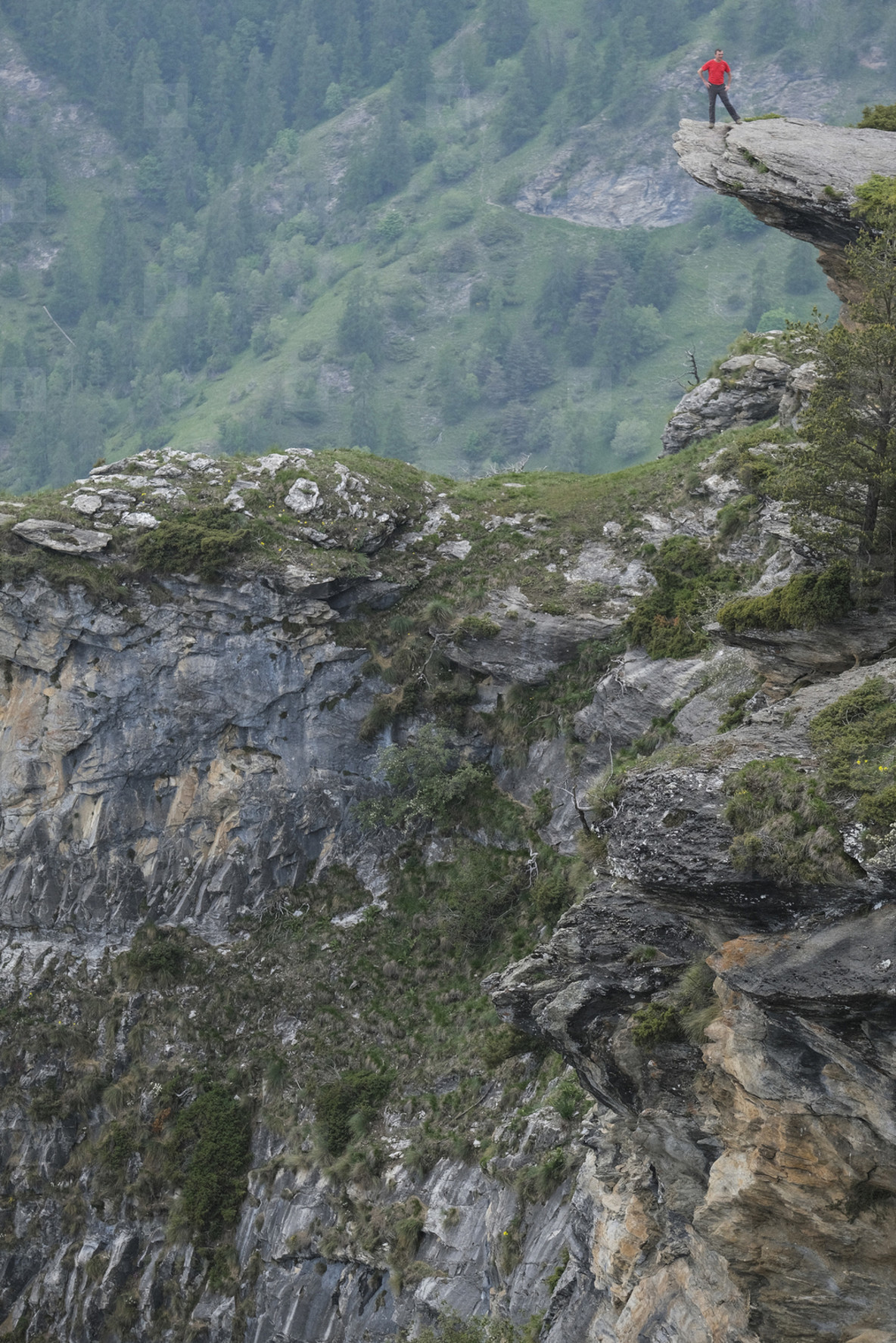 Man standing at the edge of rugged mountain cliff  Italy