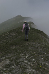 Man with backpack hiking along mountain ridge Italy