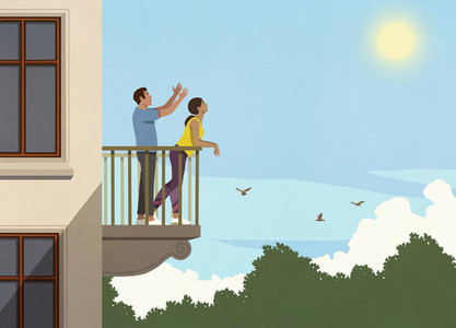 Happy couple enjoying sunshine on apartment balcony