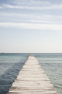 Wooden pier over sunny ocean Spain