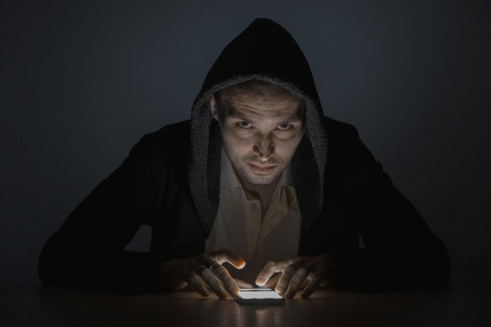 Portrait serious man using smart phone in the dark