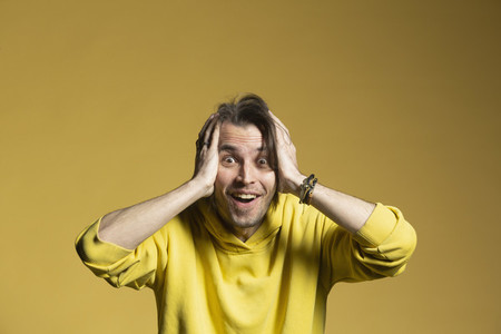 Portrait excited surprised man on yellow background
