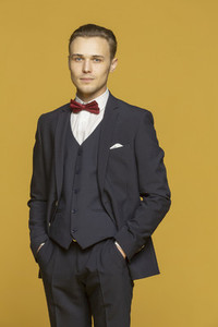 Studio portrait handsome young man in three piece suit with bow tie