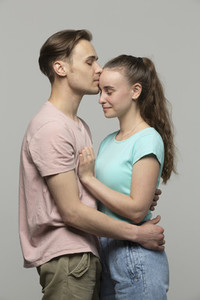Studio portrait affectionate tender young couple hugging