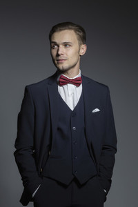 Portrait handsome young man in three piece suit with bow tie