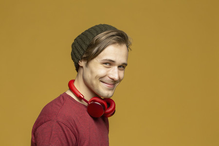 Studio portrait happy young man with headphones