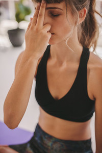 Young woman doing breathing exercise