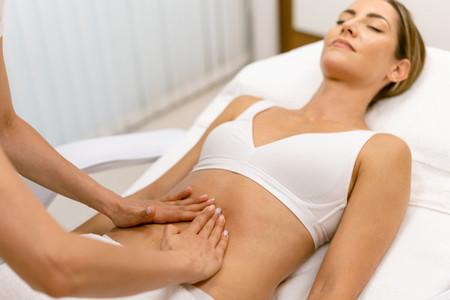 Middle aged woman having a belly massage in a beauty salon