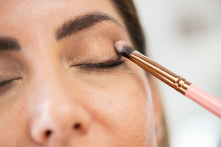 Close up of a make up artist applying eye shadow to her client