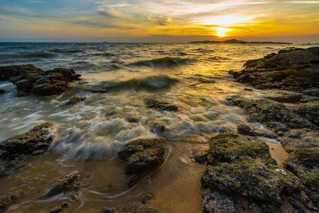 Sea waves crashed against rocks in the sunset at Pattaya Thailan