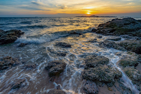 Sea waves crashed against rocks in the sunset at Pattaya Thailan