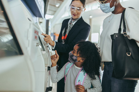Attendant helping a family doing the self check in at the airpor