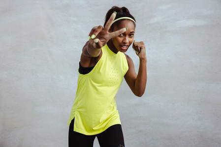 African sportswoman exercising with peace handsign