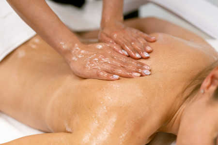 Woman receiving a back massage with massage candle oil